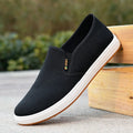 Men's black low-top slip-on canvas shoes with a round toe and composite sole on a white background.