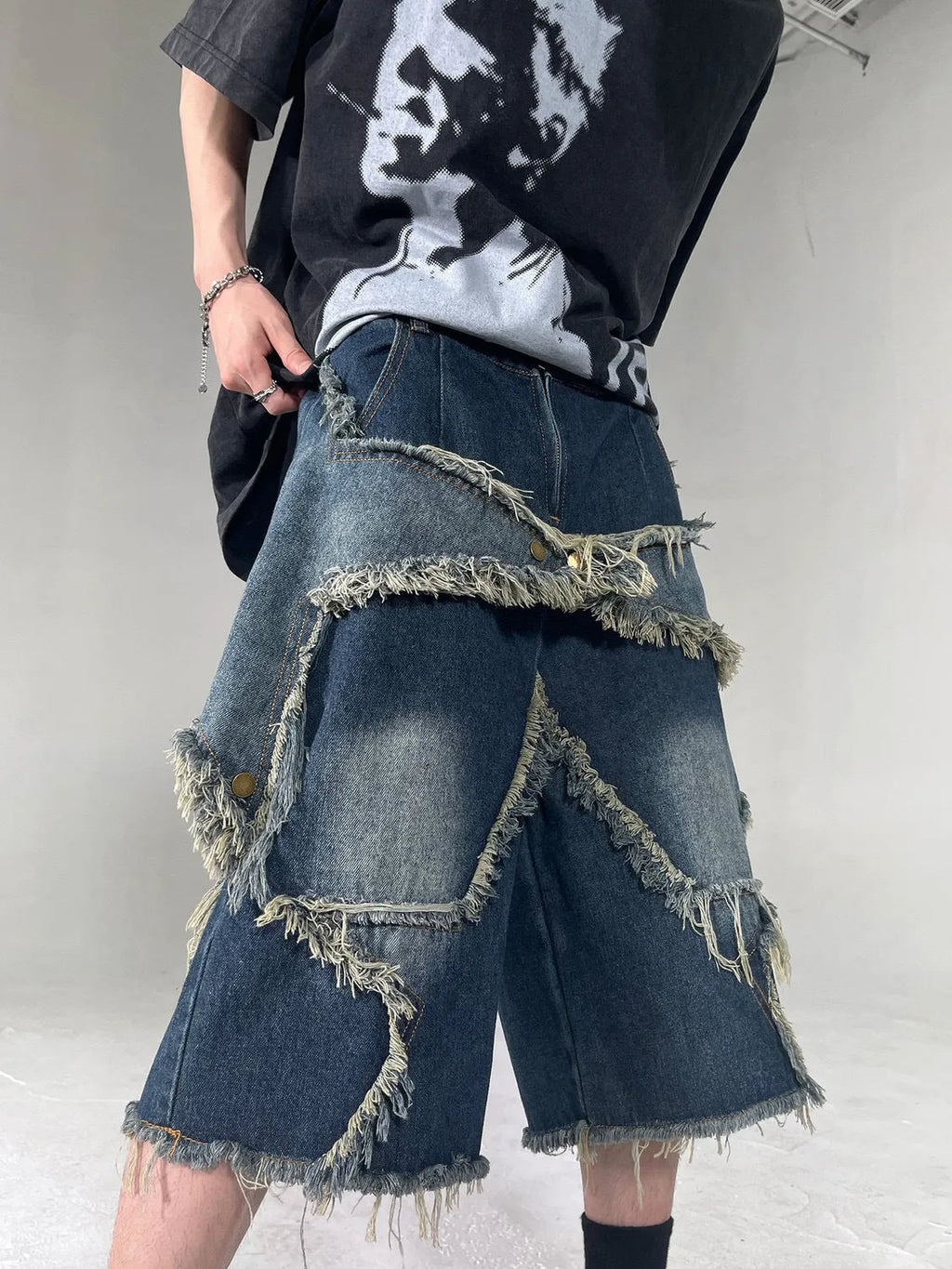 Men's blue distressed denim shorts with a large five-pointed star and frayed hem in a loose cargo fit.