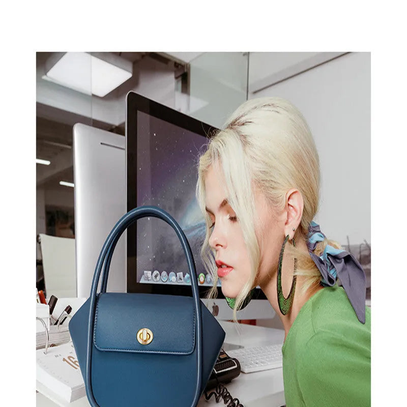 A soft cow leather wing-shaped tote handbag with a buckle and shoulder strap in black.