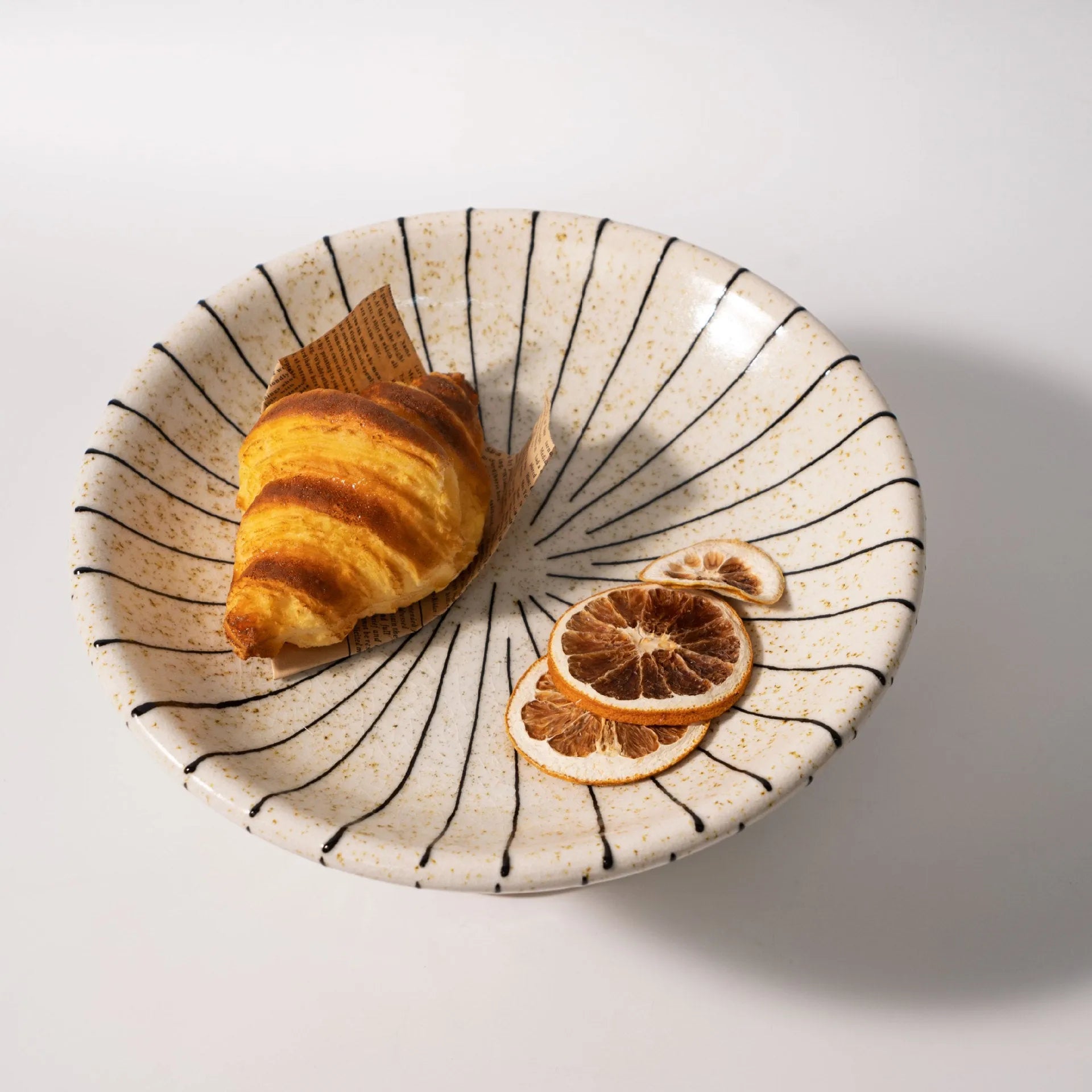 Black and white striped resin fruit plate on a table for dessert serving.