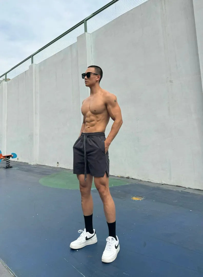 Men's ice silk quick-drying double-layer shorts in light grey, showing casual fit and elastic waistband.