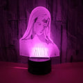 3D LED night light with colourful dual-ring pattern, remote control, and USB cable on a desk.