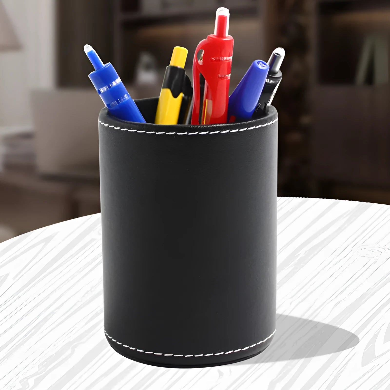 Round black leather pen container measuring 8.0cm diameter and 10.8cm height
