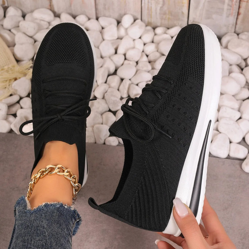 Women's low-top fly-knit sneakers in black, blue, or red with round toe and lace-up front.
