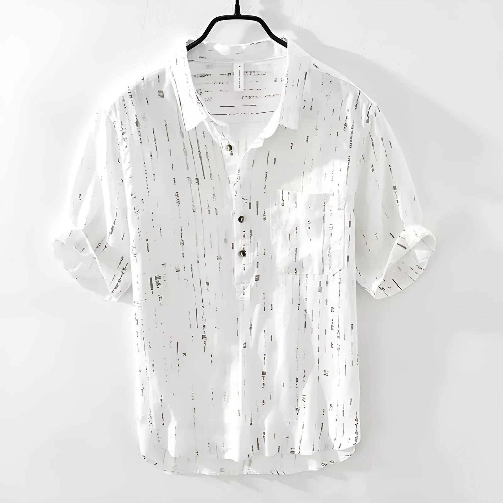 A man's loose-fitting black lapel polo shirt with short sleeves on a hanger.
