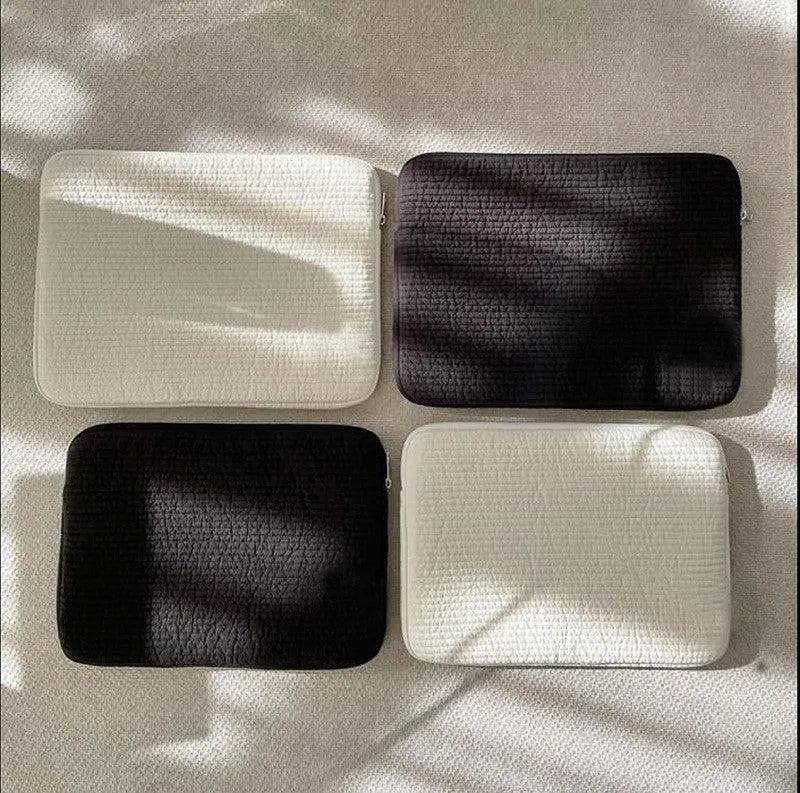 Black and white hand-held anti-seismic cotton laptop clutch bag for tablets, showing coin pocket.