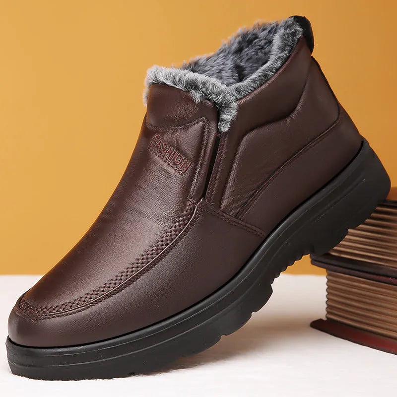 Men's black fleece-lined winter slip-on shoes with rubber sole on a wooden floor.