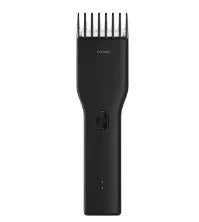 Black and white Boost model cordless hair clipper with adjustable comb on a stand