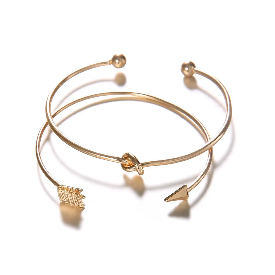 Gold-toned vintage women's cuff bracelet with an intricate arrow knot design.