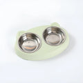 Blue plastic double bowl pet feeding tray for cats and dogs with non-slip rubber feet on a floor.