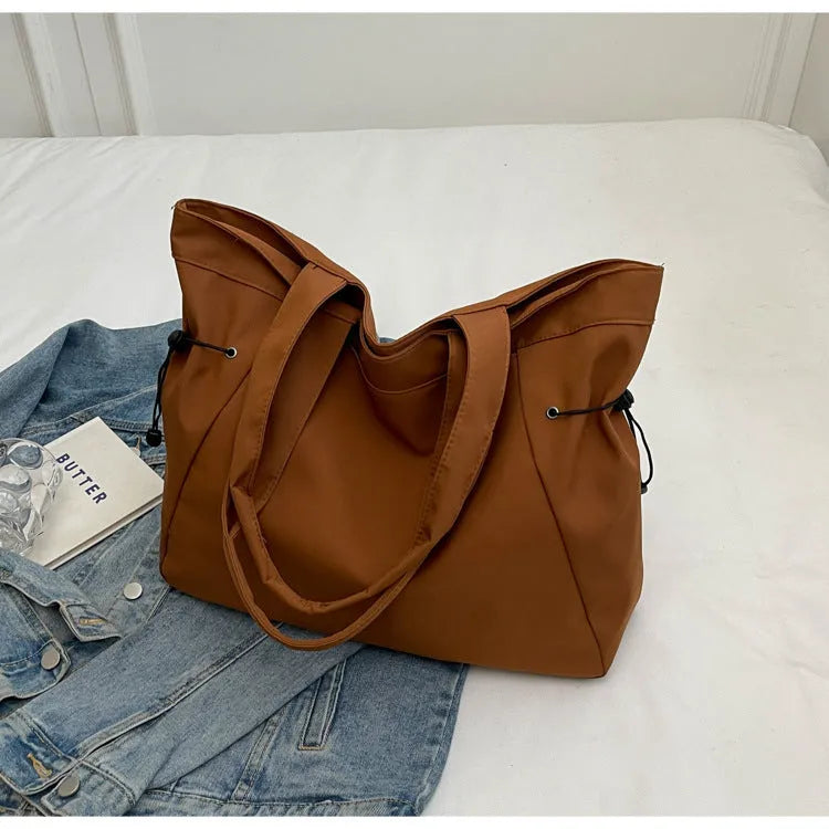Soft oxford cloth folding commuter tote bag in street style, shown in black, grey, brown, and purple colours.