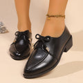 Women's brown leather-look shoes with a decorative bow detail on a flat rubber sole