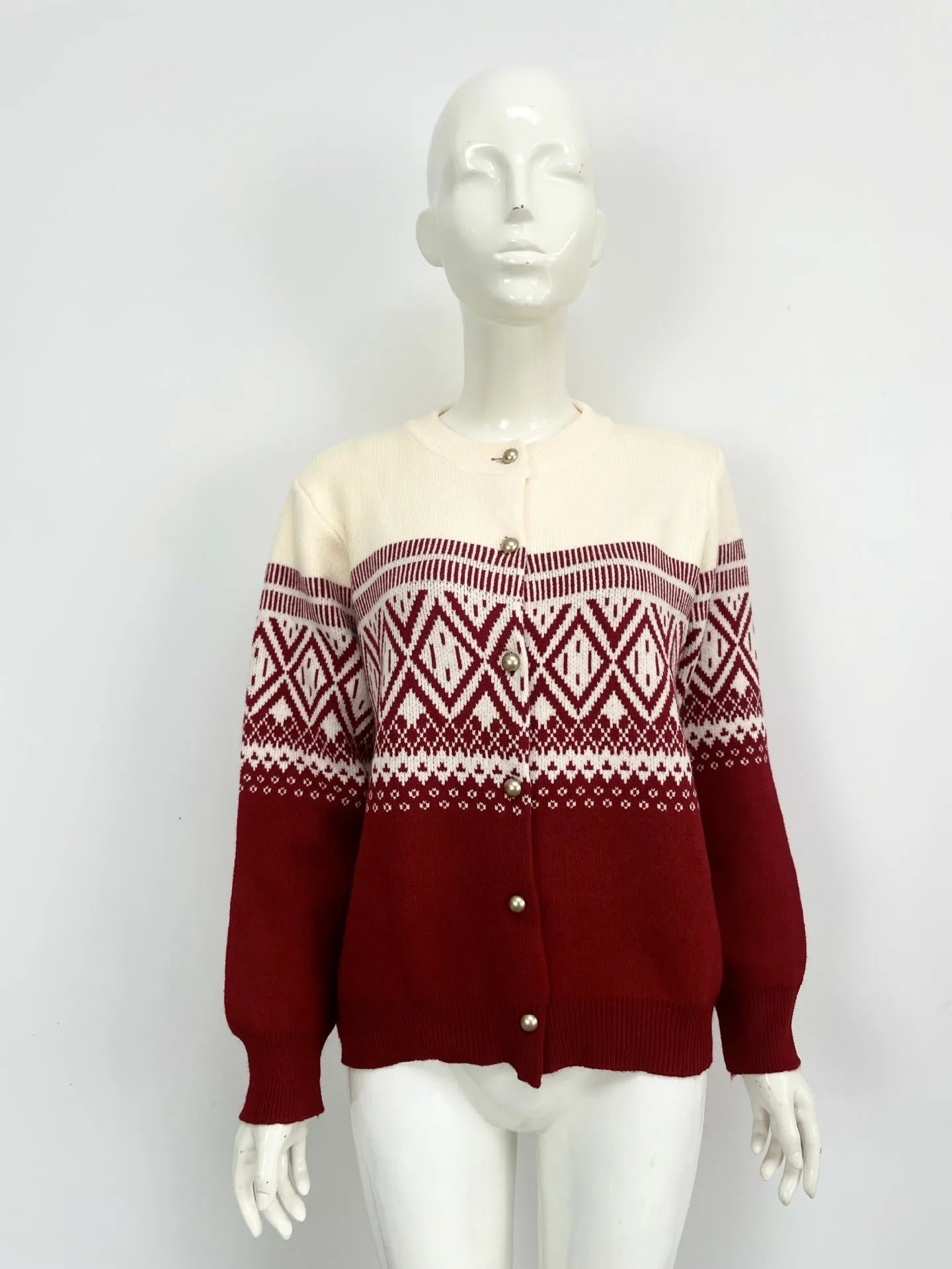 Woman wearing a grey alpaca wool cardigan with a long sleeve diamond pattern in a contrast colour.