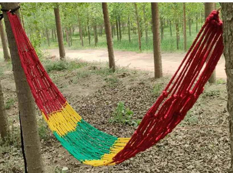 Outdoor nylon rope mesh hammock hanging between two trees, showing its woven construction and spacious 1.1m by 2.1m size.
