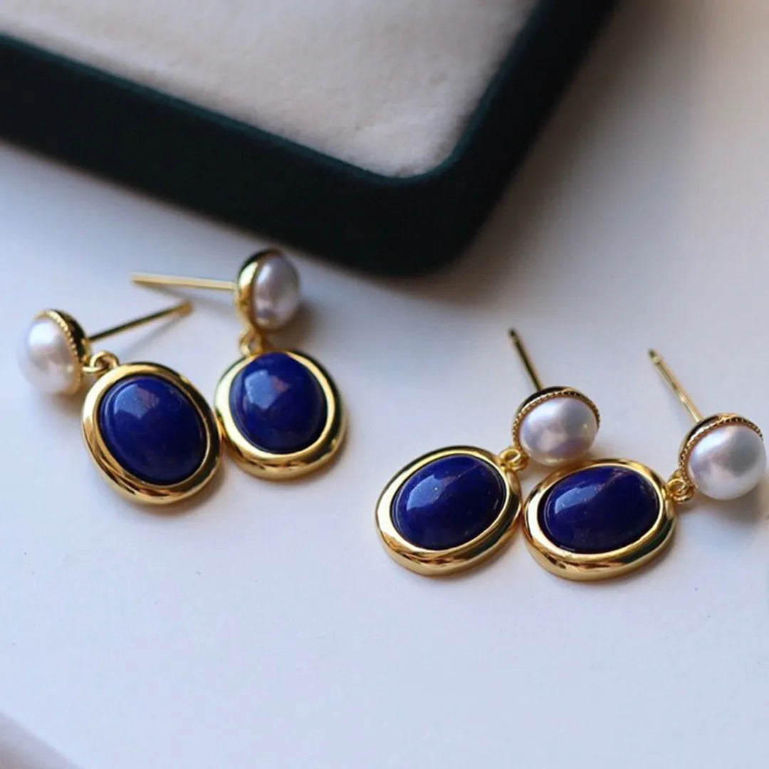 A pair of simple stud earrings with a blue lapis lazuli pearl set in sterling silver.