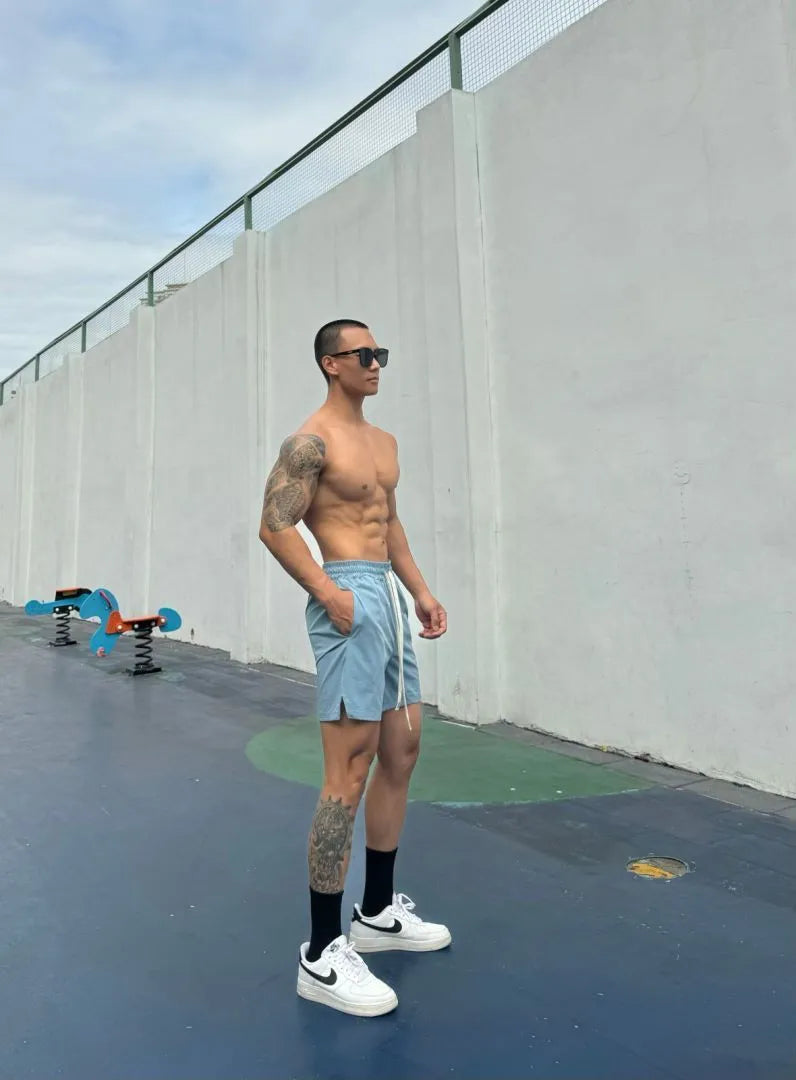 Men's ice silk quick-drying double-layer shorts in light grey, showing casual fit and elastic waistband.