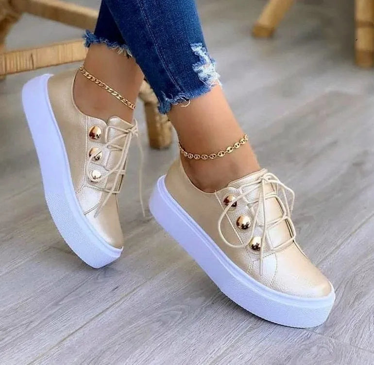 Women's lace-up flats sneakers with rivet detail, artificial PU upper, round toe, and polyurethane sole in white, black, gold, or rose gold.