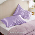 A pair of solid colour satin pillowcases in various colours and sizes on a bed.