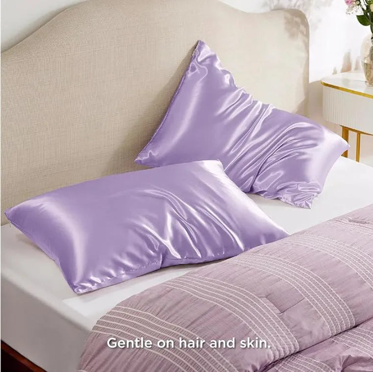 A pair of solid colour satin pillowcases in various colours and sizes on a bed.