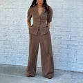 Brown slim fit two-piece suit with long sleeves and matching trousers on a hanger.