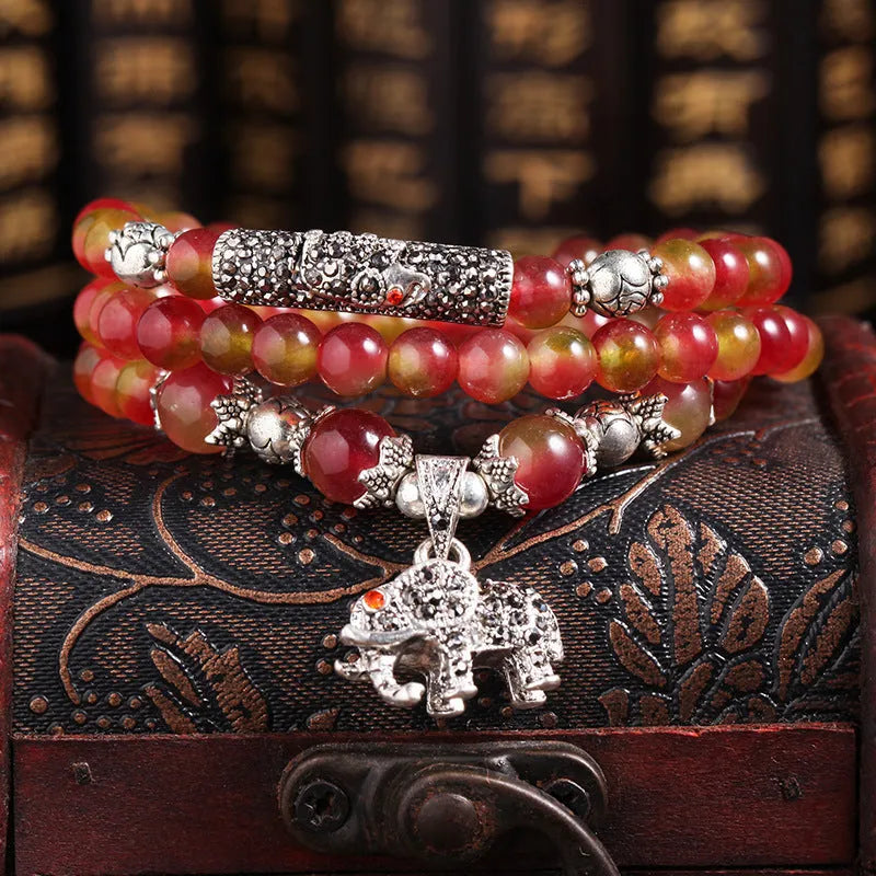 Handmade bracelet with a watermelon crystal elephant bead on a Chinese knot cord.