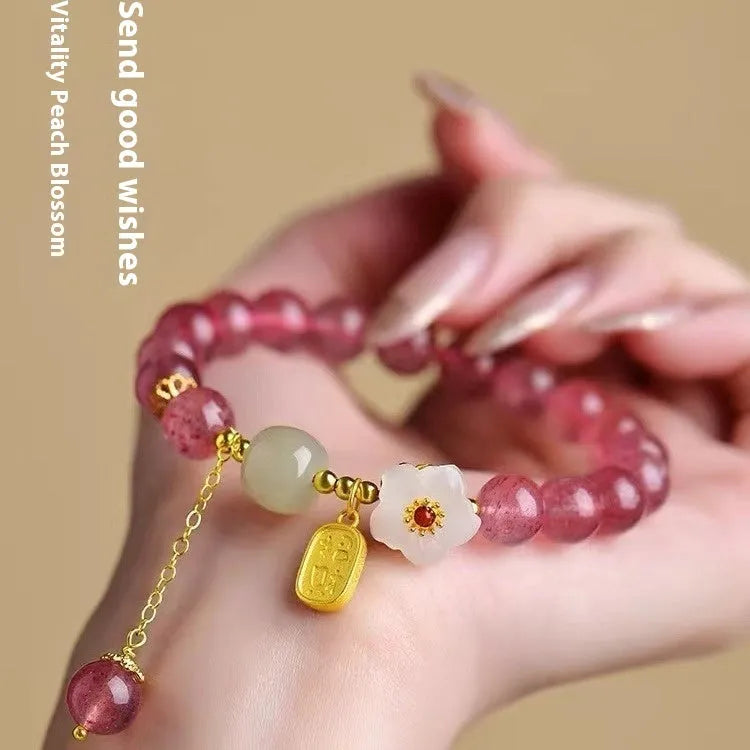 Adjustable strawberry quartz bracelet with Hetian jade peach blossom charm on wrist