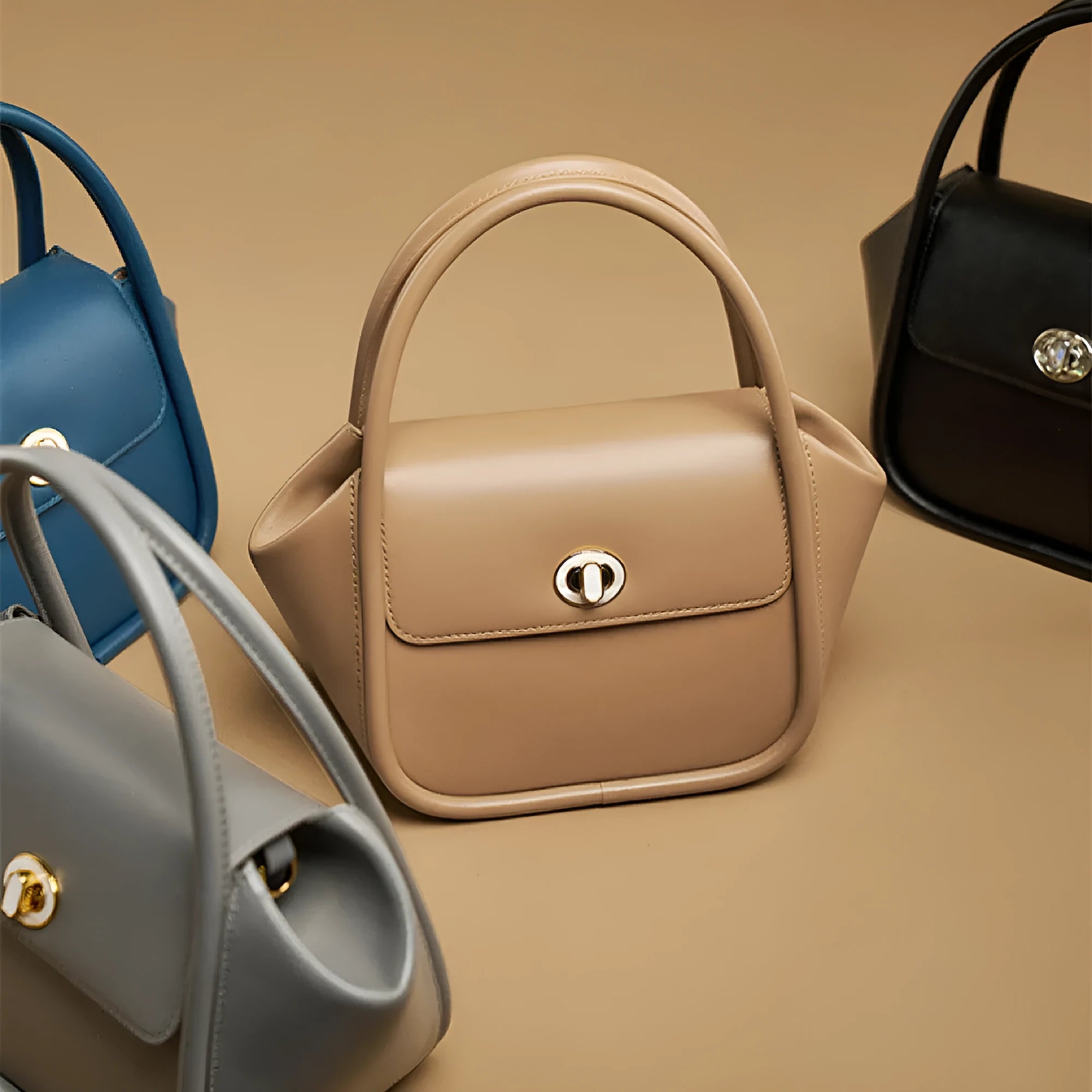 A soft cow leather wing-shaped tote handbag with a buckle and shoulder strap in black.