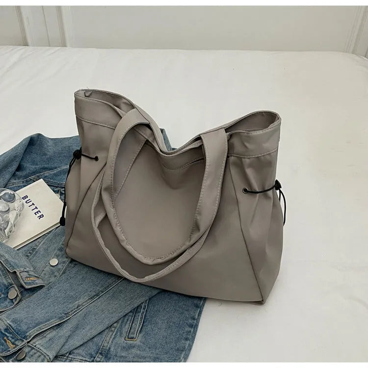 Soft oxford cloth folding commuter tote bag in street style, shown in black, grey, brown, and purple colours.