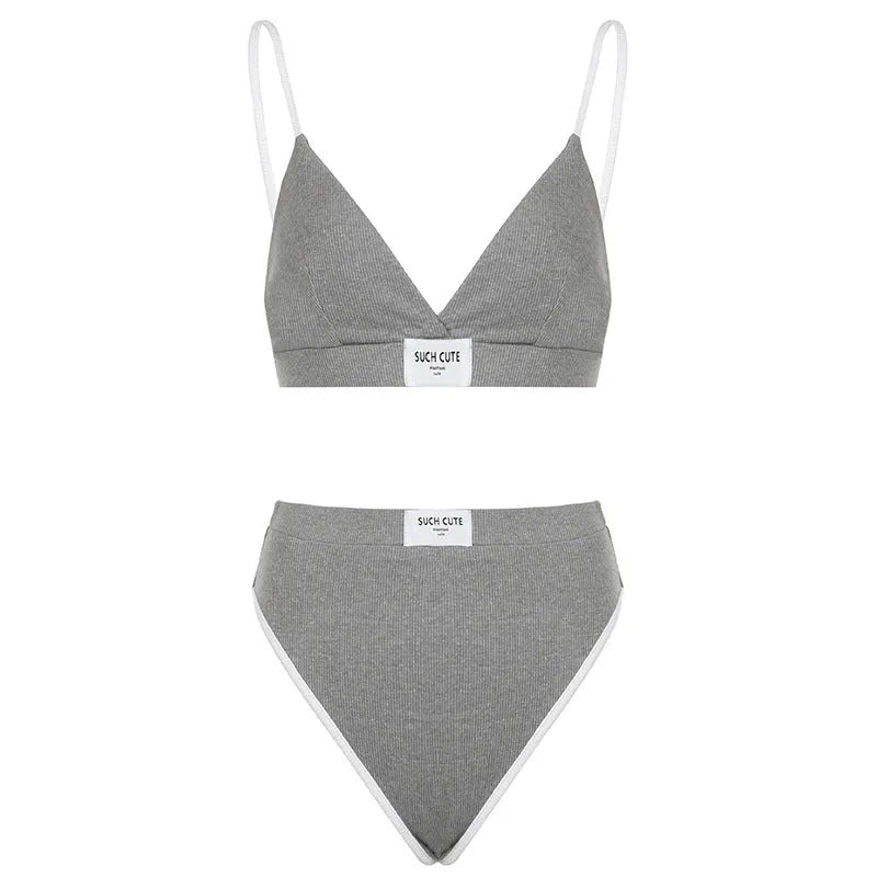 Women's black bikini set with white embroidery and contrast binding, showing sleeveless top and shorts.