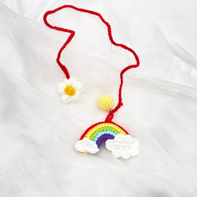 Handmade crocheted car pendant with avocado and rainbow colours hanging from rear-view mirror