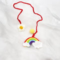 Handmade crocheted car pendant with avocado and rainbow colours hanging from rear-view mirror