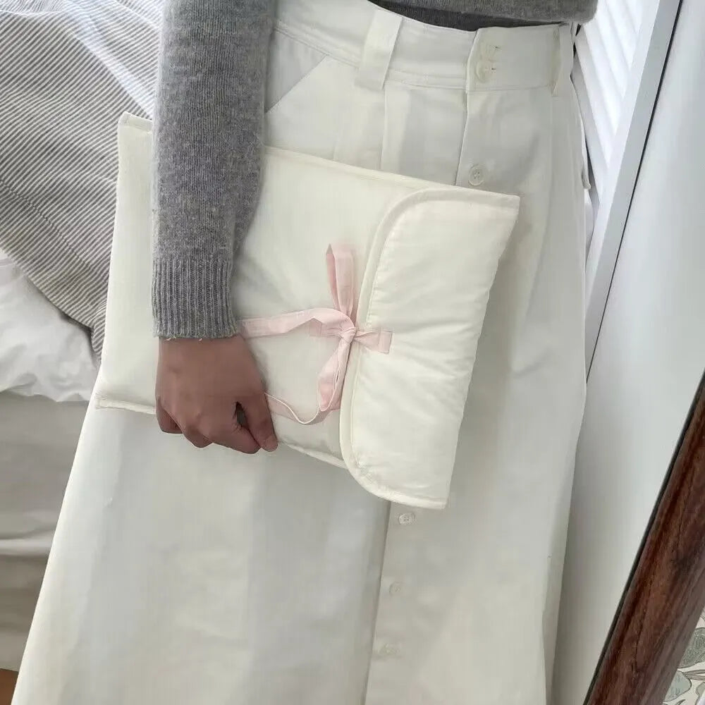 Women's black quilted computer bag with ballet bow detail showing striped nylon lining