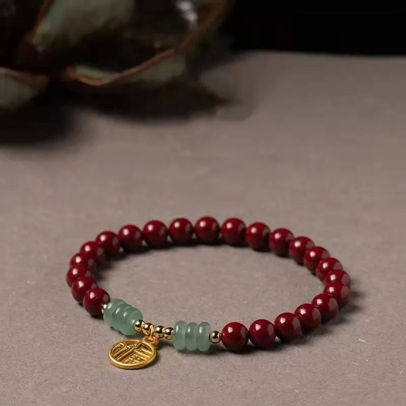 Gold cinnabar and copper bead bracelet in a wave shape on a wrist.