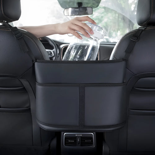 Black leather car seat storage bag with a carbon fibre pattern, shown between vehicle seats.