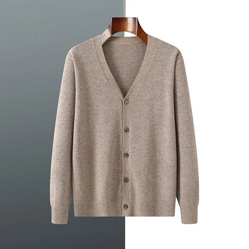 Man wearing a beige V-neck Andy velvet knitted cardigan coat with long sleeves and a loose fit.