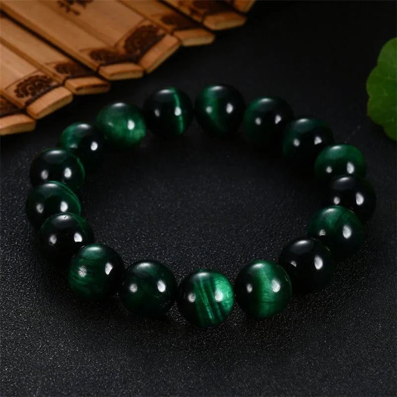 Green tiger eye stone bracelet with geometric beads on a wrist.