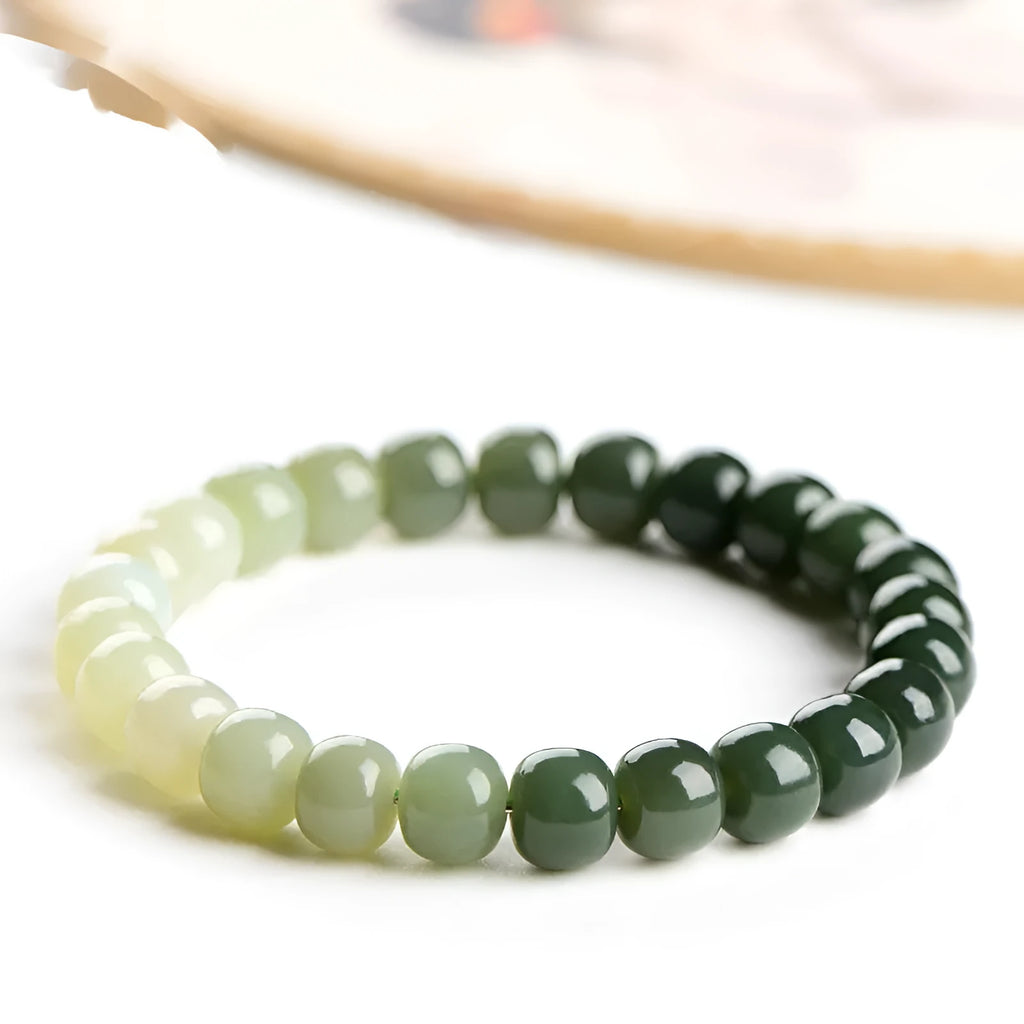 Natural Hetian Jade bracelet showing water gradient colour on wrist, with polished beads.