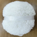 Oversized plush dry powder puff measuring 150x75mm for loose powder application in white skin colour