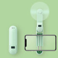 Green folding mini fan with leaf-shaped plastic blades, shown open and ready for use