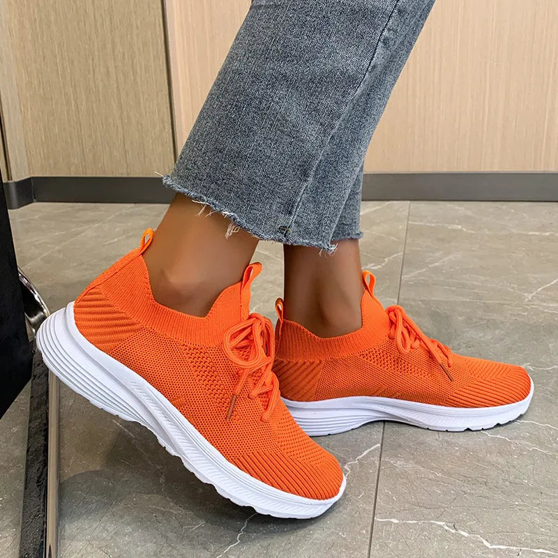 Women's mesh running shoes in creamy white with Flyknit upper and flat rubber sole