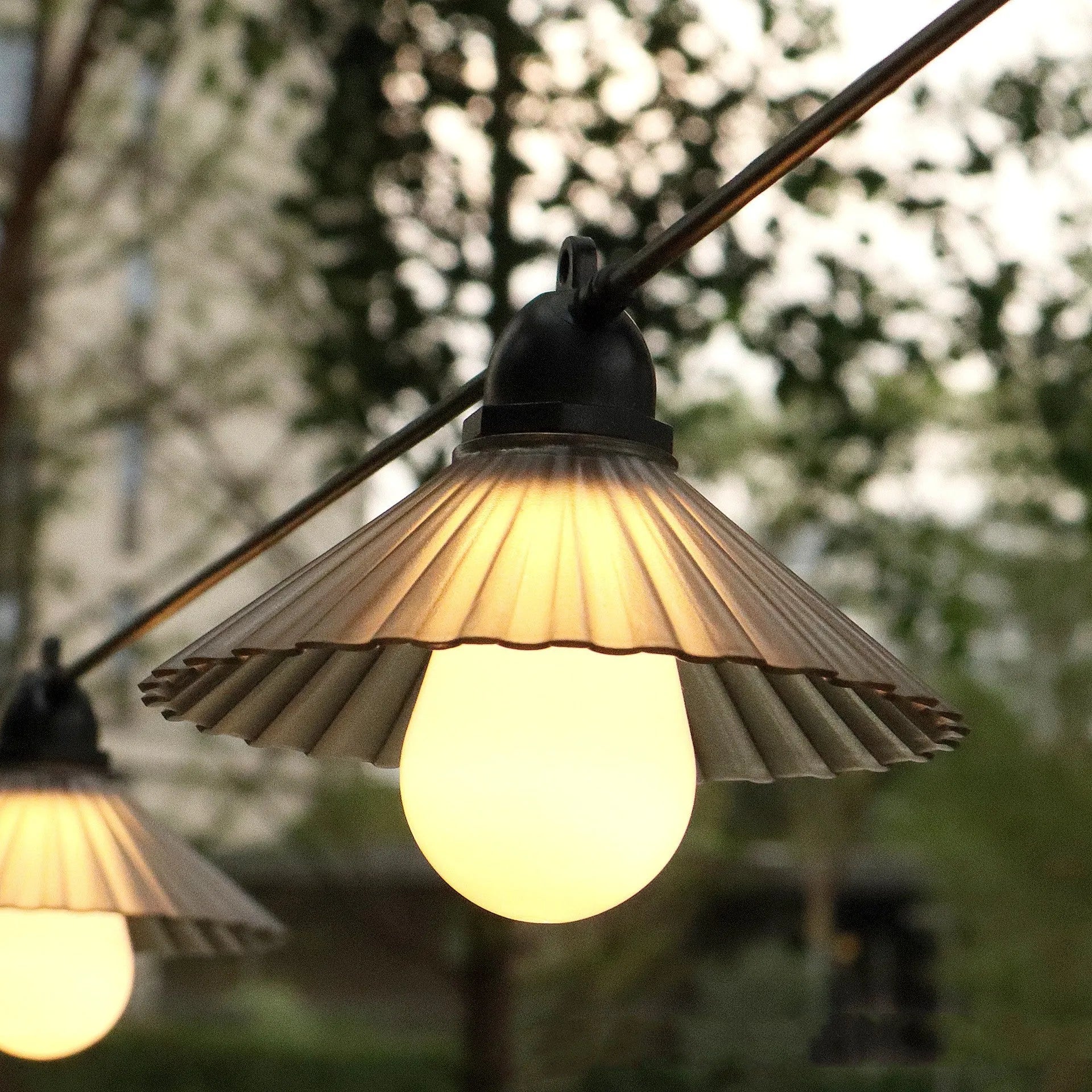 Outdoor LED string lights with flower-shaped bulbs in garden setting showing IP65 waterproof rating