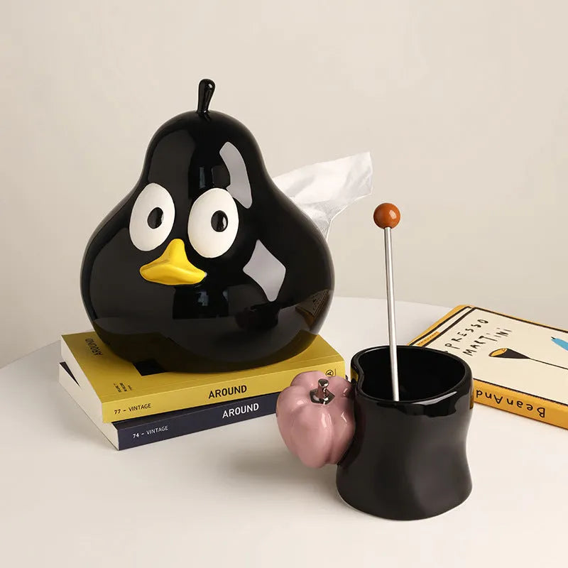 A cute pear-shaped white ceramic tissue box holder with an animal design, shown in green and black colour options.
