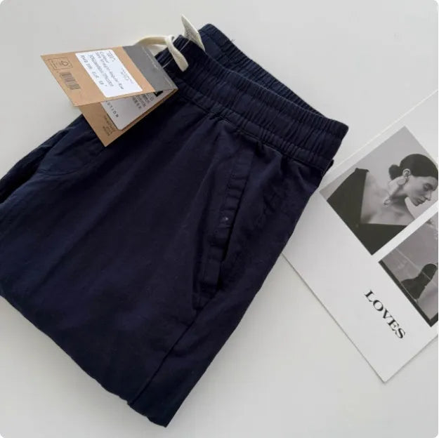 Men's beige loose-fit straight-leg casual pants with a drawstring waistband on a hanger.