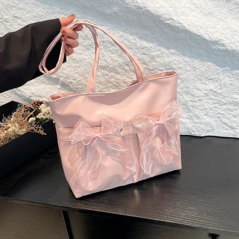 Black college-style bow tote bag with double shoulder straps and zippered compartment