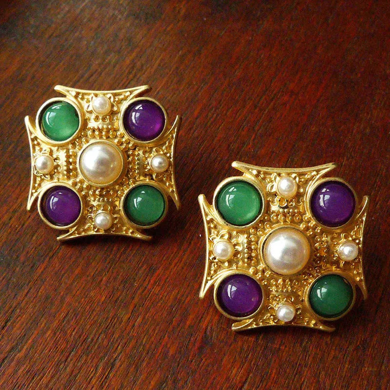 A vintage-style baroque brooch made of zinc alloy in a diamond shape on a fabric background.
