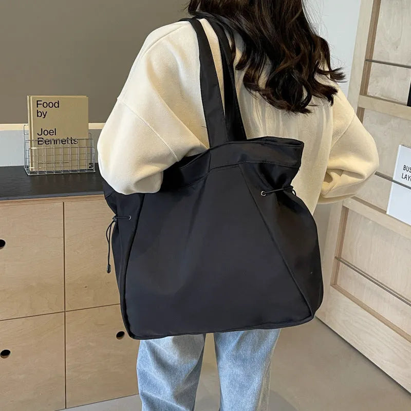 Soft oxford cloth folding commuter tote bag in street style, shown in black, grey, brown, and purple colours.
