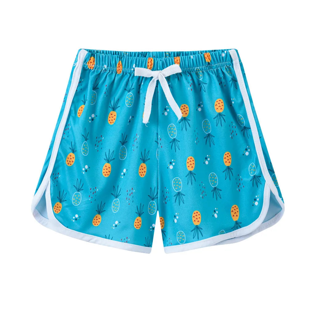 Children's patterned beach shorts in various colours including leopard print, floral, and fruit designs