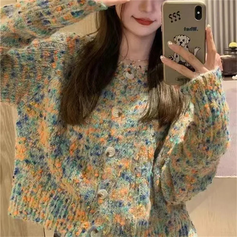 Pink and green retro style slim-fit knitted cardigan sweater on a hanger.