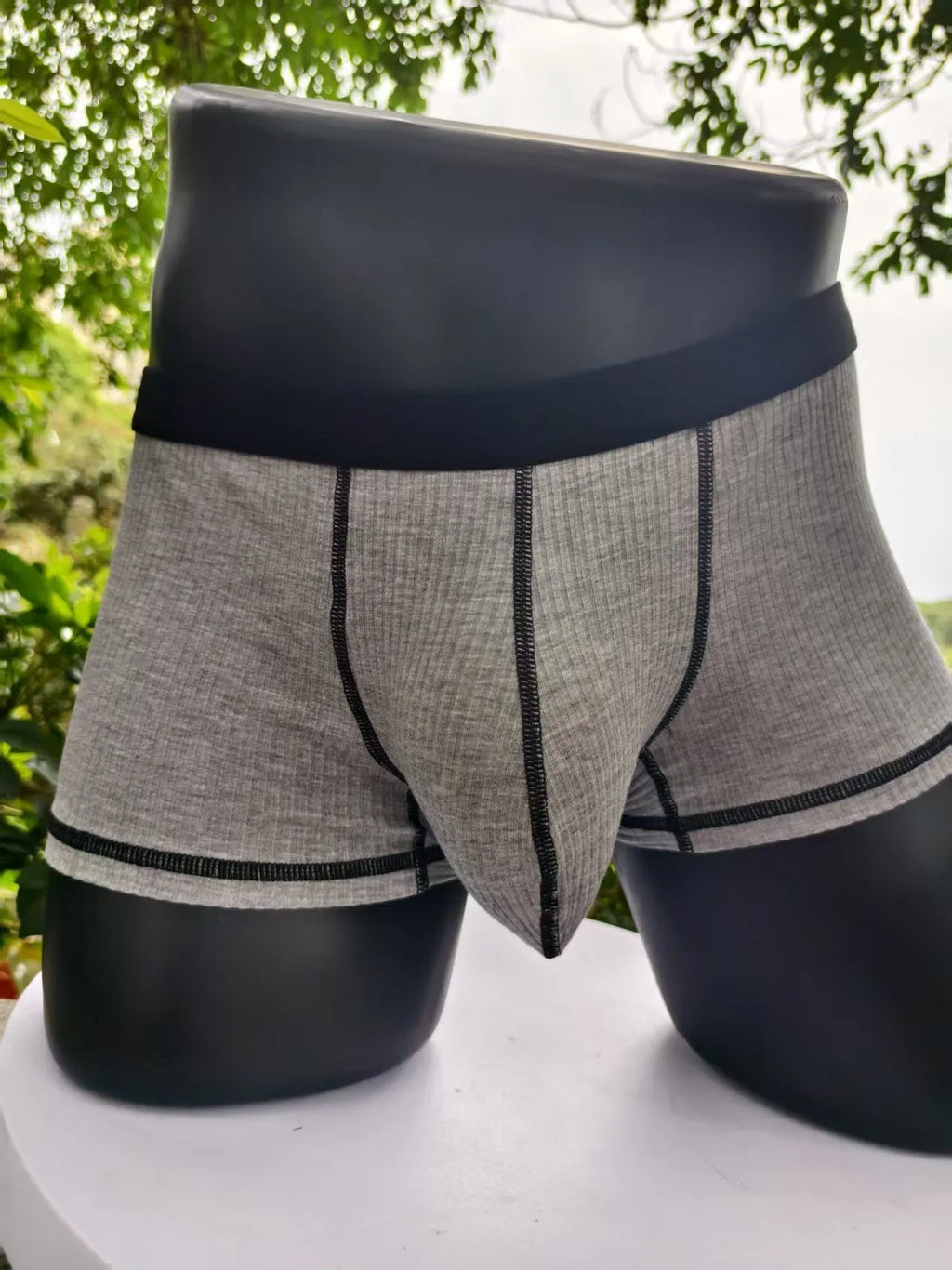Solid-colour men's boxers in breathable fibre fabric on a size chart.