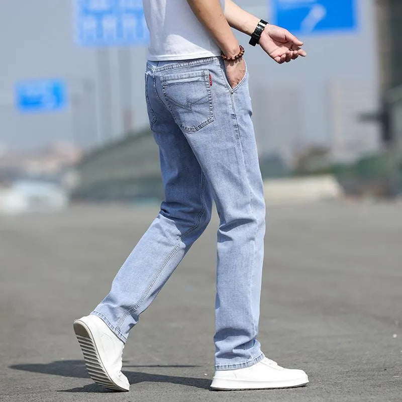 Man wearing smoky grey straight leg men's jeans with a low waist and zip fly.